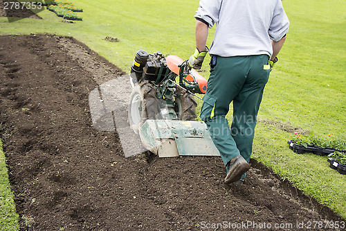 Image of Man rototilling the ground 