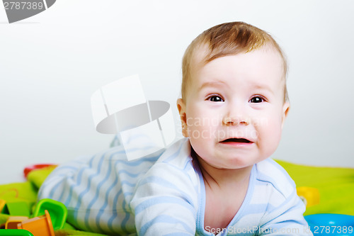 Image of Little baby boy with toys weeps