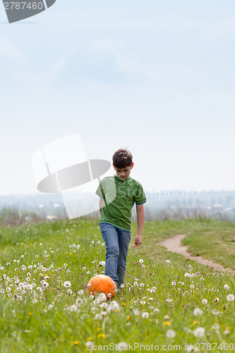 Image of Cute boy with football outdoors