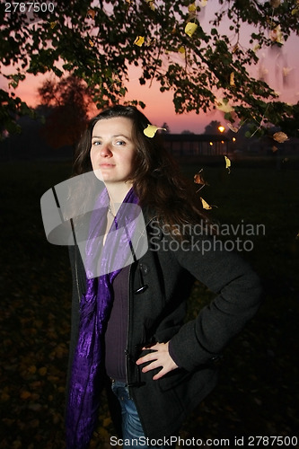 Image of Happy young brunette in autumn park 