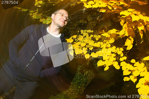 Image of Man in autumn park enjoys