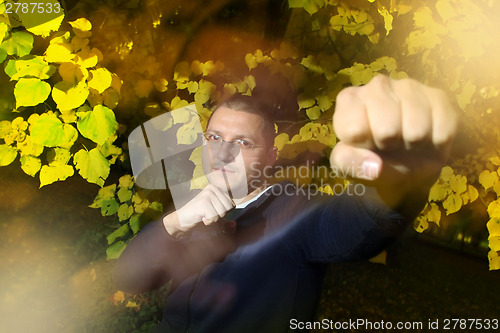 Image of Man in autumn park with fighting pose