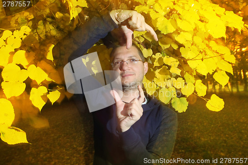 Image of Man in autumn park with strange pose