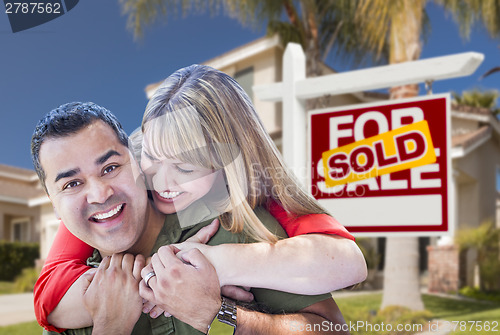 Image of Couple in Front of Sold Real Estate Sign and House