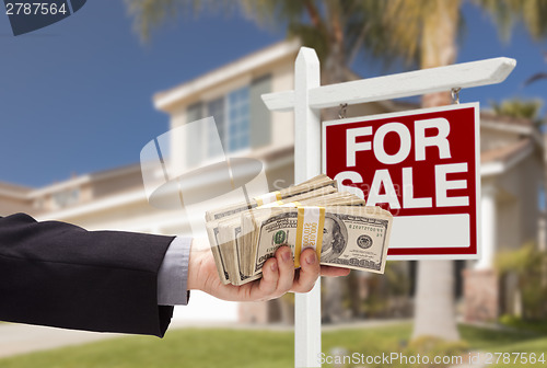 Image of Buyer Handing Over Cash for House with For Sale Sign