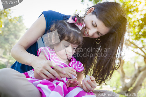Image of Young Mother and Cute Baby Girl Applying Fingernail Polish