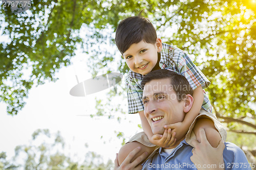 Image of Father and Son Playing Piggyback in the Park