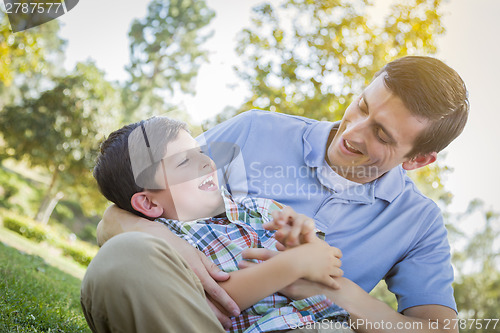 Image of Loving Father Tickling Son in the Park