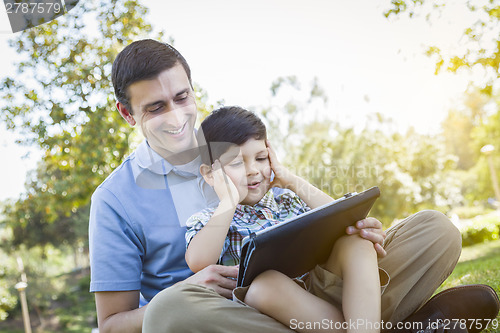 Image of Handsome Mixed Race Father and Son Playing on Computer Tablet