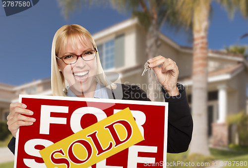 Image of Excited Woman Holding House Keys and Sold Real Estate Sign