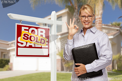 Image of Real Estate Agent in Front of Sold Sign and House