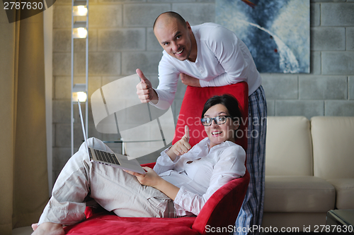 Image of young couple using Laptop computer at home