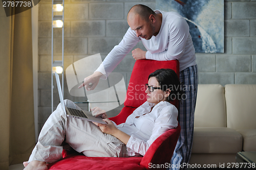 Image of young couple using Laptop computer at home