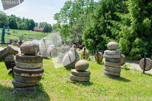 Image of millstones stone figure in meadow landscape park  