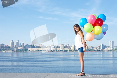 Image of Happy young woman with colorful balloons