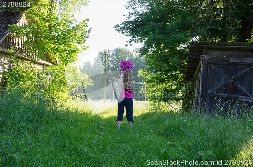 Image of woman pose with flower on sunlit garden background