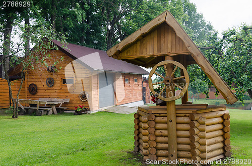 Image of Rural well manhole decor and house made of logs