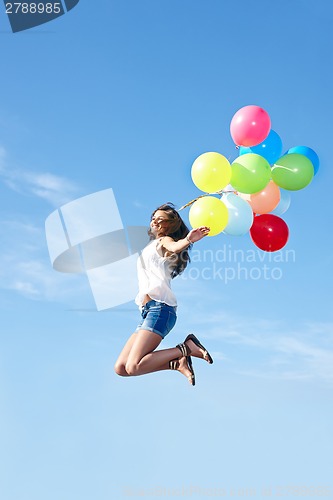 Image of Happy young woman jumping with colorful balloons
