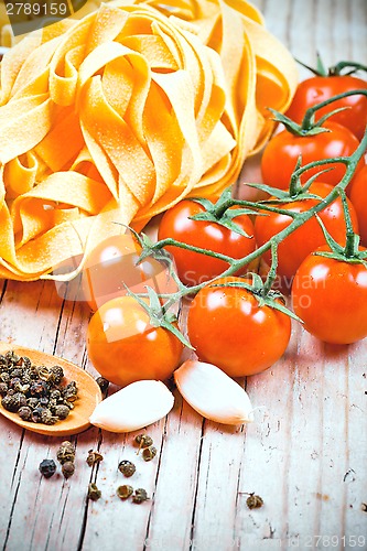 Image of uncooked pasta, fresh tomatoes and spices 