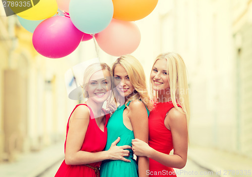 Image of beautiful girls with colorful balloons in the city