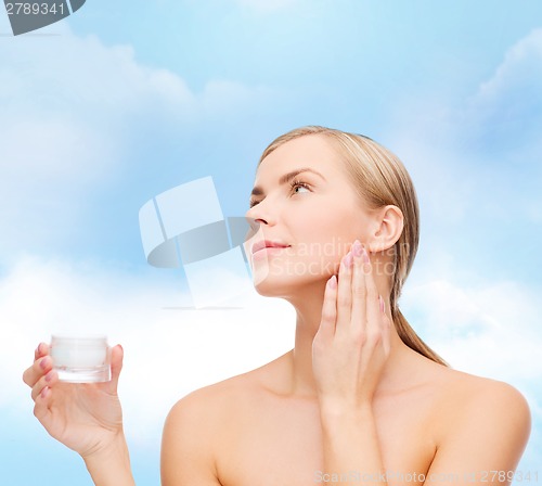 Image of woman applying cream on her skin