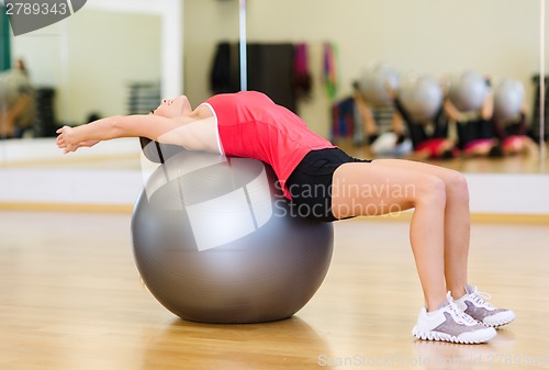 Image of young woman doing exercise on fitness ball