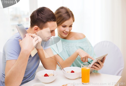 Image of smiling couple with tablet pc reading news