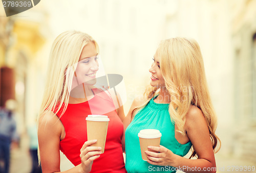 Image of two women with takeaway coffee cups in the city