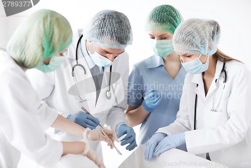 Image of young group of doctors doing operation