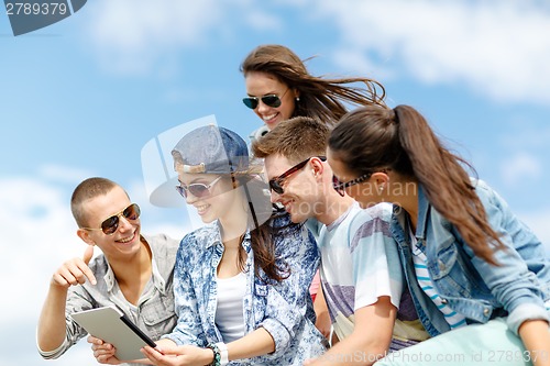 Image of group of teenagers looking at tablet pc computer
