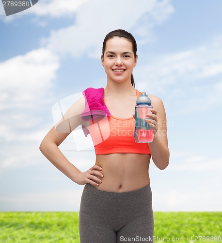 Image of sporty woman with towel and water bottle