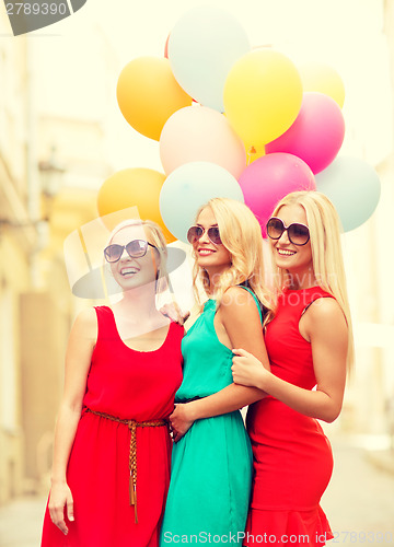 Image of beautiful girls with colorful balloons in the city