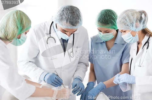 Image of young group of doctors doing operation