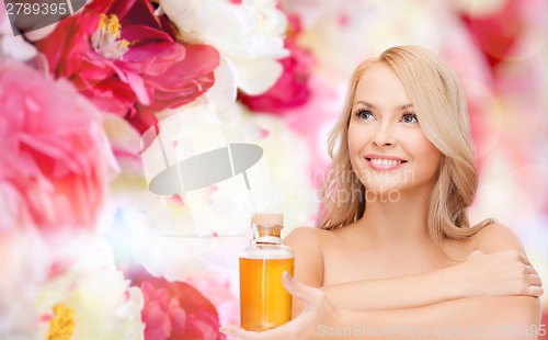 Image of happy woman with oil bottle