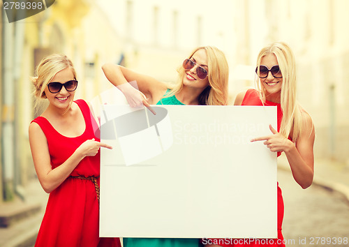 Image of three happy blonde women with blank white board