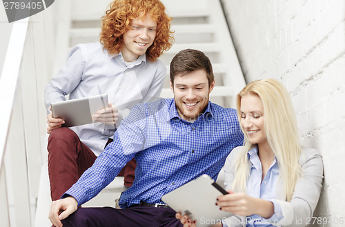 Image of team with tablet pc computer sitting on staircase