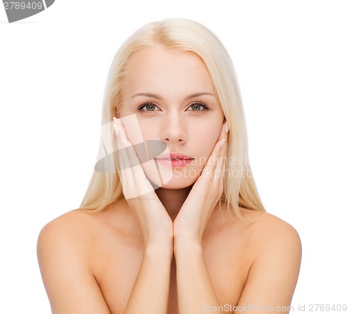 Image of face of beautiful woman touching her face skin