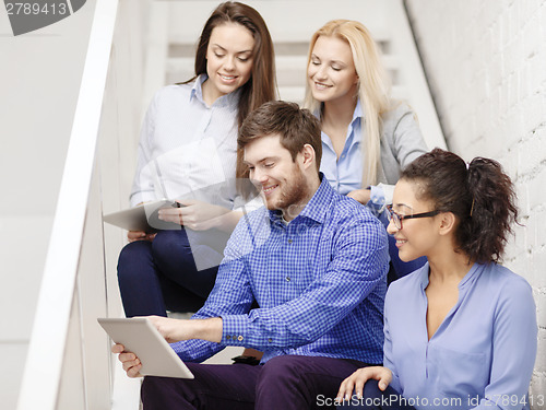 Image of team with tablet pc computer sitting on staircase