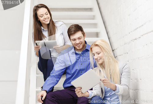 Image of team with tablet pc computer sitting on staircase