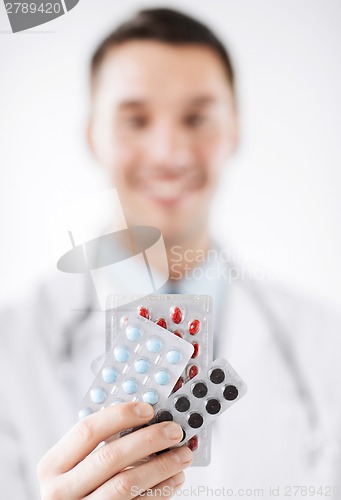 Image of male doctor with packs of pills