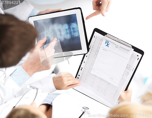 Image of group of doctors looking at x-ray on tablet pc