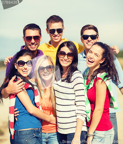 Image of group of friends having fun on the beach