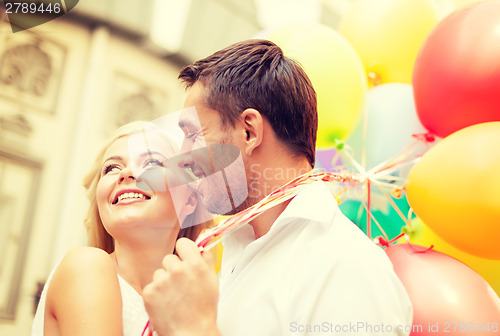 Image of happy couple with colorful balloons