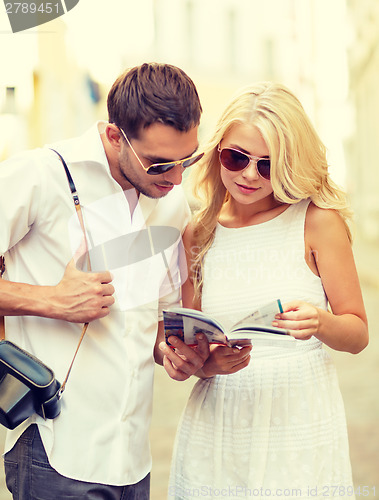 Image of couple with map, camera and travellers guide