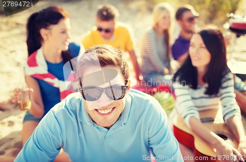 Image of smiling man in sunglasses on the beach