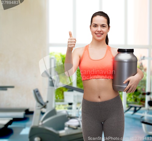 Image of teenage girl with jar of protein showing thumbs up