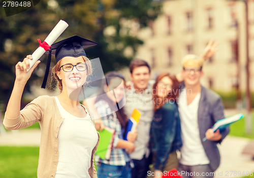 Image of smiling teenage girl in corner-cap with diploma