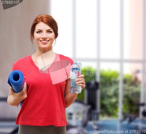 Image of smiling girl with bottle of water after exercising