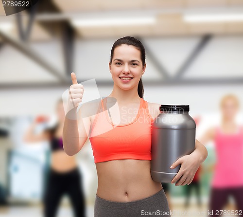 Image of teenage girl with jar of protein showing thumbs up