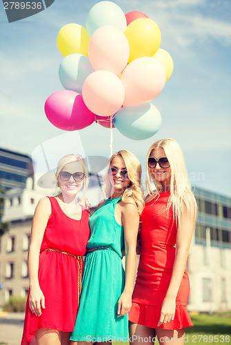 Image of beautiful girls with colorful balloons in the city